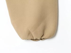 Close-up of elastic ribbed cuff and premium knit fabric on the light brown jacket