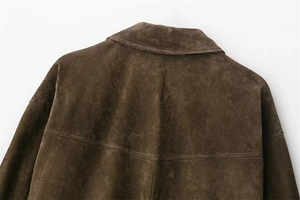 Détail de la texture en daim marron foncé et des coutures sur la veste aviateur vintage