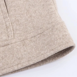 Macro detail of oatmeal wool blend jacket hem showing high-quality stitching and texture
