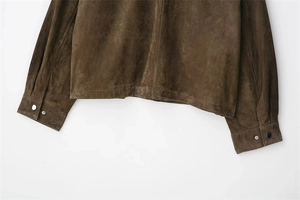 Macro de l'ourlet de la veste en daim marron foncé avec boutons-pression aux poignets