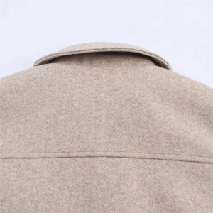 Detailed macro view of beige wool texture and precise stitching on the back collar area