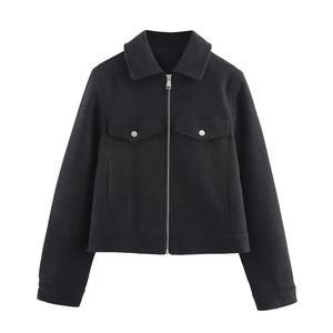 Close-up of black wool jacket featuring silver zipper and dual chest flap pockets