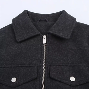 Detail of dark charcoal zip-up jacket with silver snaps and thick wool texture