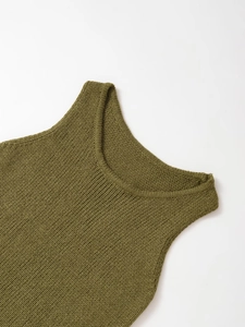 Detail of green knitted sleeveless top showing neckline stitching and cotton fabric texture