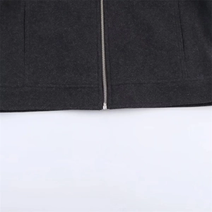Detailed close-up of dark grey jacket featuring textured fabric and silver metal zipper