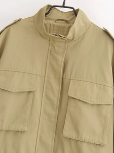 Detail of khaki cargo jacket featuring high collar, epaulets, and large flap pockets