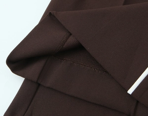 Détail de la texture du tissu marron foncé avec rayures blanches et coutures du pantalon