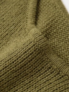 Macro view of olive green chunky knit cotton fabric showing thick ribbed texture