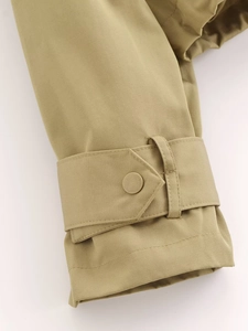 Detailed close-up of khaki twill jacket sleeve featuring an adjustable buttoned cuff strap