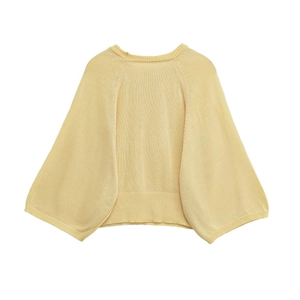 Close-up of ribbed cuffs and hem on a light yellow knit sweater with drop shoulder detail