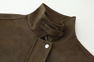 Detail of high stand collar and metal buckle strap on faux suede bomber jacket