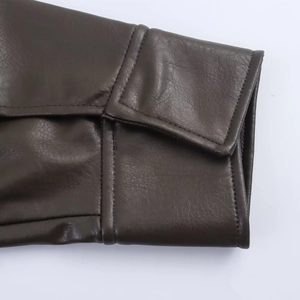 Detail of double-stitched cuffs and premium leather texture on brown PU jacket