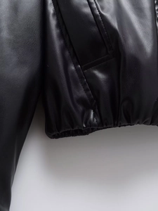 Detail of the elastic hem and stitched side pockets on the black faux leather jacket