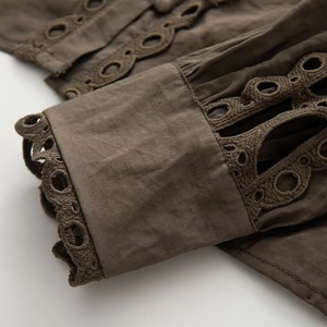 Detailed macro view of dark coffee cotton fabric featuring delicate eyelet lace embroidery