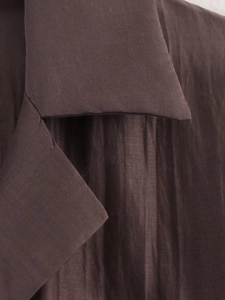 Detail of dark brown satin shirt featuring pointed collar and fine vertical ribbed texture