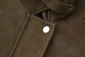 Detail of premium faux suede jacket fabric with metallic snap buttons and neat stitching