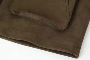 Detail of brown faux suede flight jacket showing premium stitching and pocket texture