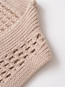 Detailaufnahme des beigen Häkelmusters und der feinen Rippbündchen am Strickoberteil