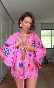 Gros plan détaillé des broderies sur le gilet kimono en coton rose à manches longues