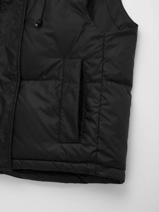 Close-up of black quilted vest featuring side pockets and adjustable drawstring cords