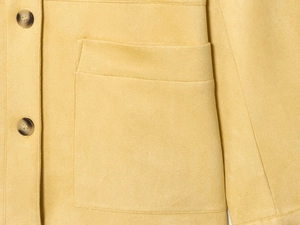 Close-up of yellow faux suede jacket featuring amber buttons and a large patch pocket