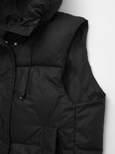 Detail of hooded black quilted puffer vest showing fabric texture and snap buttons