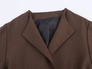 Detailed macro view of dark brown woven blazer fabric with lapel and black inner lining