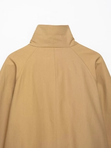 Detail of the stand collar and raglan sleeve stitching on this khaki short trench coat