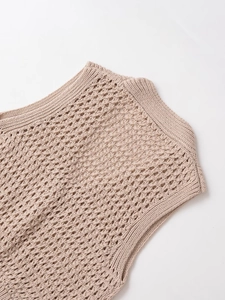 Detail der beigen Strickweste mit V-Ausschnitt und aufwendigem Rauten-Häkelmuster-Design