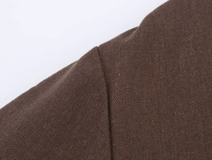 Macro shot of dark brown fabric shoulder stitching and fine texture on casual jacket