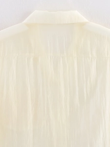 Detailed macro view of cream long sleeve shirt collar and textured fabric weave