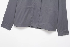 Detail of grey hooded jacket hem and cuffs with reinforced stitching and hidden buttons