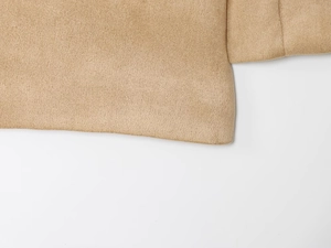 Detailed view of camel suede jacket hem and cuffs showing high-quality stitching texture