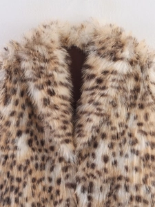 Gros plan d'un manteau en fausse fourrure léopard, texture pelucheuse et col en V
