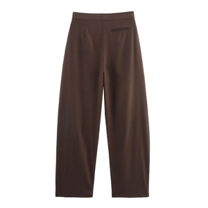 Detail of high-waist dark brown wide-leg trousers with front pleats and smooth fabric texture