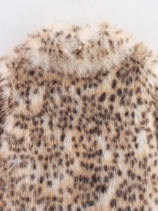 Gros plan sur un manteau en fausse fourrure léopard montrant texture et col en détail