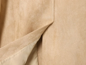 Detailed close-up showing the suede texture and precise stitching on a camel blazer jacket