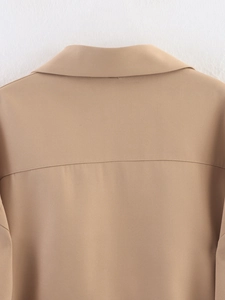 Detail of khaki jacket collar with precise horizontal stitching and smooth fabric texture