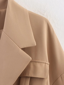 Detail of a khaki notch lapel blazer featuring a flap pocket and twill fabric texture