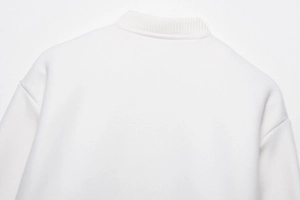 Detail der weißen Bomberjacke mit geripptem Ausschnitt und überschnittenen Schulternähten