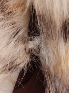 Détail macro de l'attache à crochet cachée et texture de fausse fourrure marron avec doublure