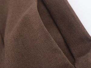 Macro view of dark coffee brown textured woven fabric showing thick fiber details and weave