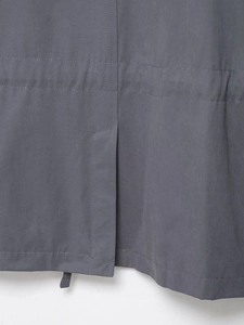Detailed close-up of dark grey cargo jacket featuring rear vent and precise double stitching