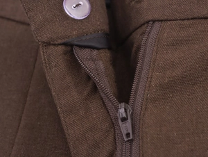 Detail of brown textured fabric featuring a matching zipper and translucent purple button