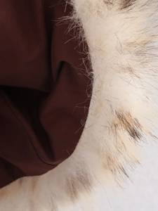 Détail de la doublure en tissu marron foncé et de la texture douce en fausse fourrure crème