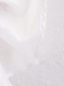 Detail shot of clean white fabric sleeve edge with neat overlock stitching and fine texture