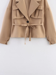 Detailed view of the khaki cropped jacket with large pleated pockets and waist tie belt