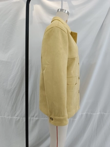 Detail view of yellow suede jacket featuring classic lapel collar and large side pockets