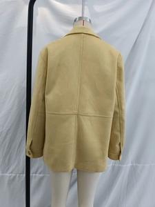 Close-up of yellow faux suede jacket back showing cross-seam design and cuff button