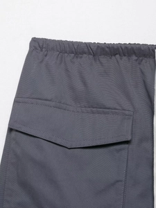 Detail of dark grey cargo skirt with elastic waistband and functional flap pocket